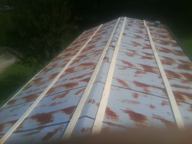 Rusted metal roof panels with new wood purlins before replacement — Storm Damage Roof Repair in Chiefland by Roofing Brothers